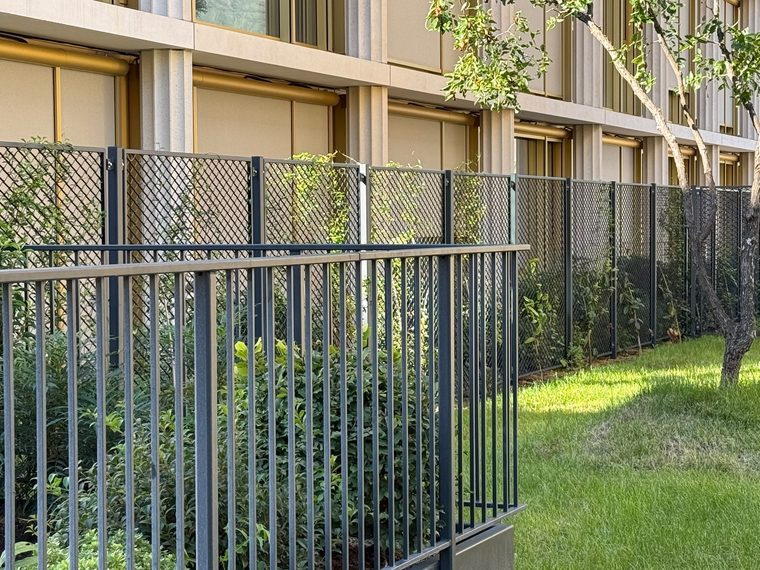 Zaun aus Streckmetall entlang der Fassade